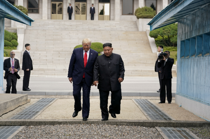 Donald Trump og Kim Jong-Un krysser grensen. Kjennetegnene på superforretningsmannen er over en kronologisk skala – iskald vurdering og beregning, presise kalkyler og nøye planlagt strategi, slu og uforutsigbar forhandlingstaktikk som kan veksle mellom hjertelige omfavnelser og det keiserlige ‘tommelen ned’, og endelig en nådeløs gjennomføring.	Her er det like før – enten utsletter jeg deg, eller så eter jeg deg. I monopolkapitalismen finnes det ingen nåde. Det er det monopolisme faktisk handler om.																								REUTERS/Kevin Lamarque