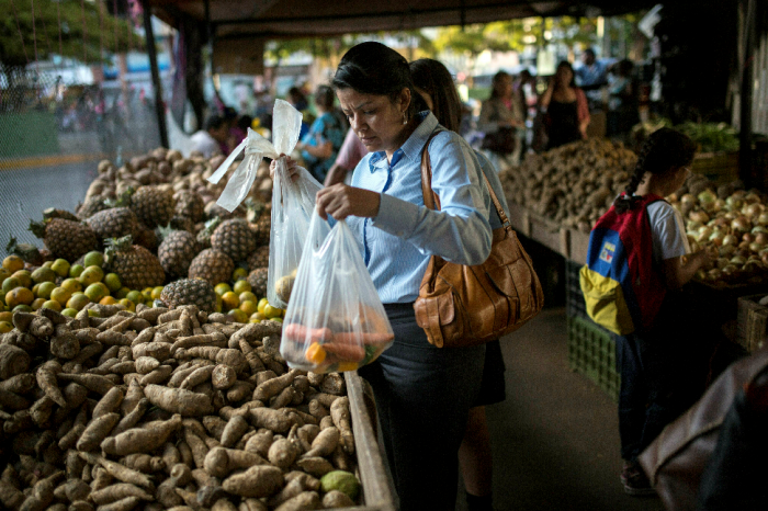 En kvinne på et marked i Caracas, Venezuela. Artikkelforfatteren skriver om klassekrigen som utkjempes i landet.								AP Photo/Rodrigo Abd