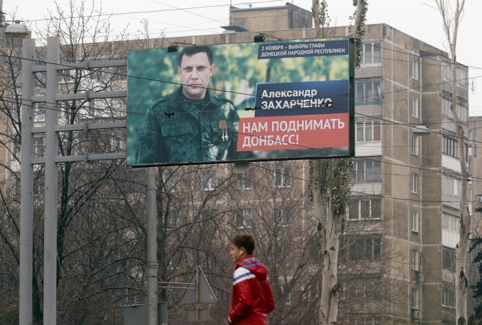 En innbygger går forbi en plakat med et portrett av Alexander Zakharchenko, 1. november 2014. Foto: REUTERS/Maxim Zmeyev
