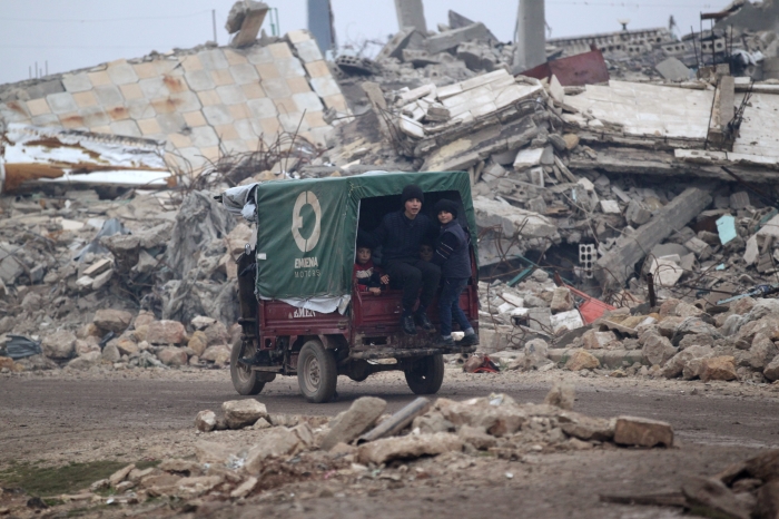 Barn sitter på i en liten lastebil, nord for Aleppo fredag 30. desember. REUTERS/Khalil Ashawi
