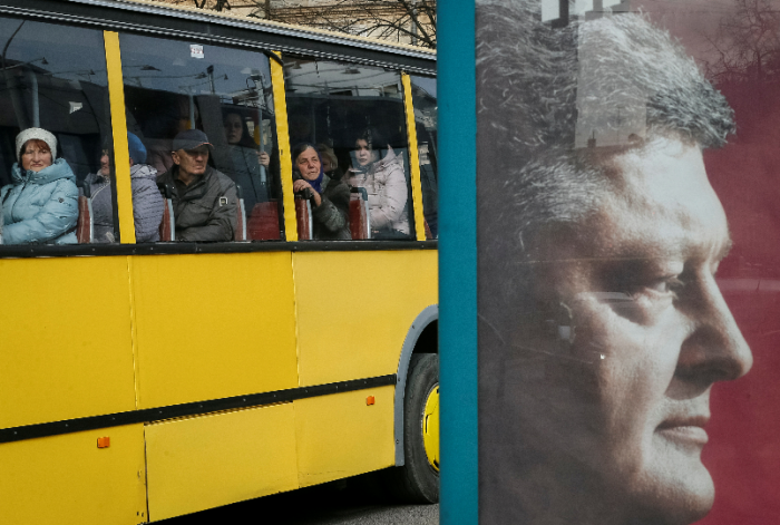 Illustrasjonsfoto: Petro Porosjenko på en valgplakat med forbipasserende buss i det sentrale Lviv, Ukraina mars 2019  REUTERS/Gleb Garanich