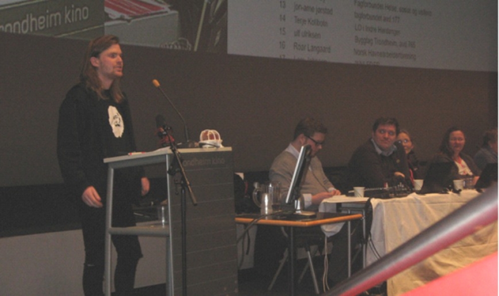 Leder av UngKom i Norge Adrian Larsen på talerstolen i storsalen Foto: Friheten/Knut Eide