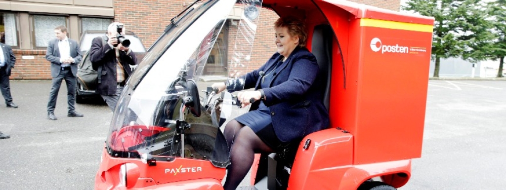 «Se hvor dette går!», statsminister Erna Solberg prøvekjørte Paxster-postbil ved åpningen av el-bilfakbrikken i Saprsborg i 2016. I ettertid kan en spørre seg om vi trenger slike i framtida eller om regjeringa rasjonaliserer bort fysiske varer. Foto: Håkon Mosvold Larsen / NTB scanpix