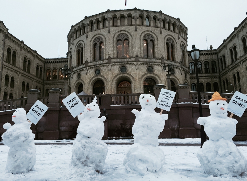 Iskald protest foran Stortinget lørdag ettermiddag. Regjeringen fastsatte tidligere denne uken en ny grense for havisen. Nå går iskanten nord for samtlige områder som er åpnet for olje- og gassvirksomhet. Flere er bekymret for at det betyr mer oljeindustri i sårbare områder, og lagde snømenn med plakater: 